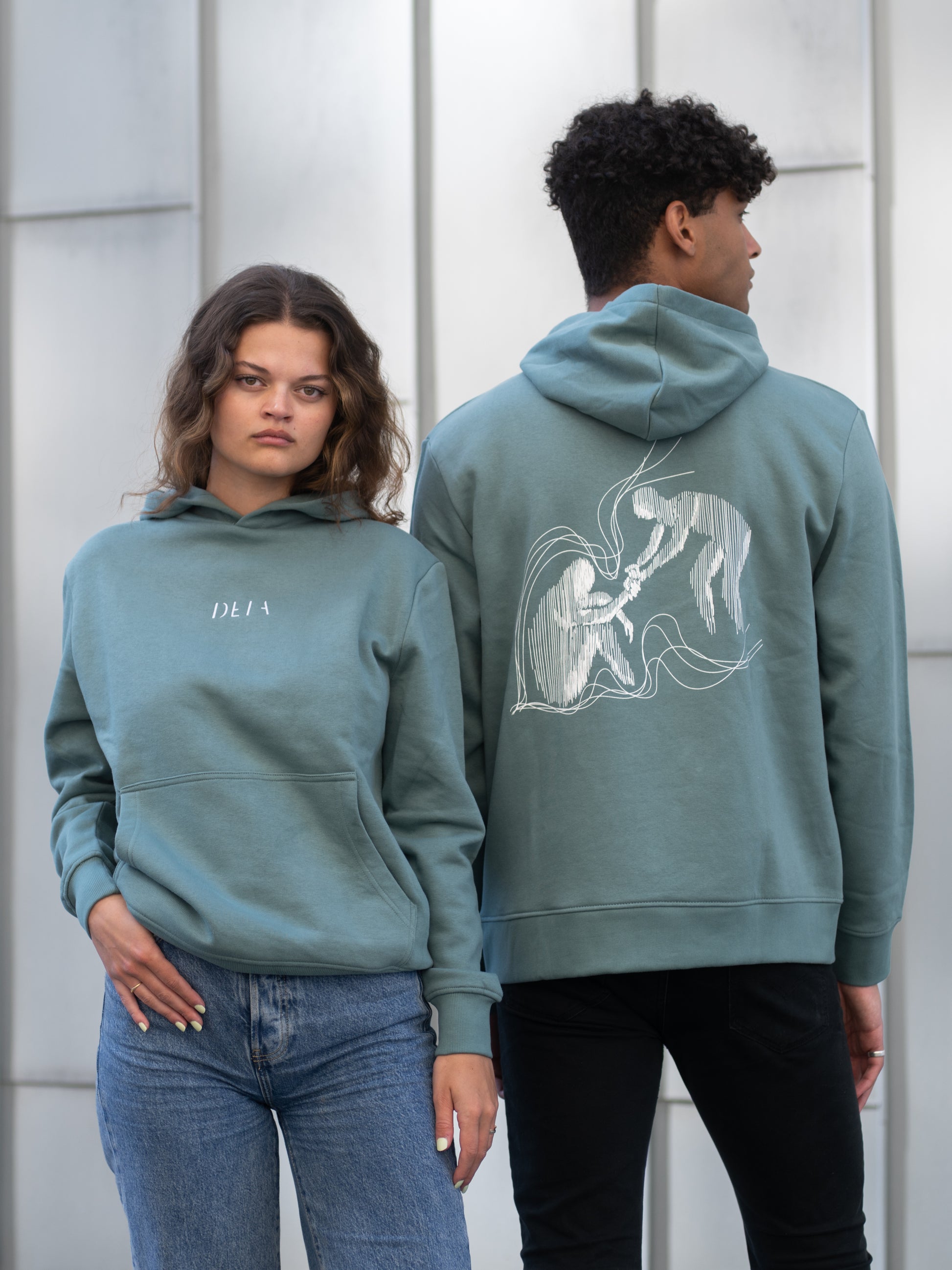 Herre og dame med unisex hoodie i grønn. Ryggen inneholder et mental-helse inspirert motiv, og logoen i front er brodert.